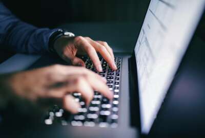 Close up of hands typing on laptop. Night work concept.